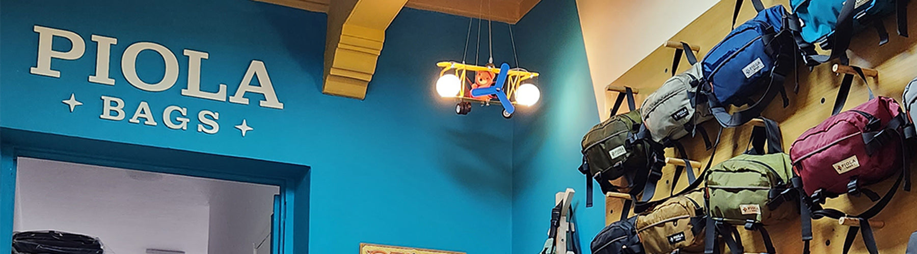 Interior de la tienda Piola Bags con canguros de colores exhibidos. Diseño sin desperdicio hecho en Perú.