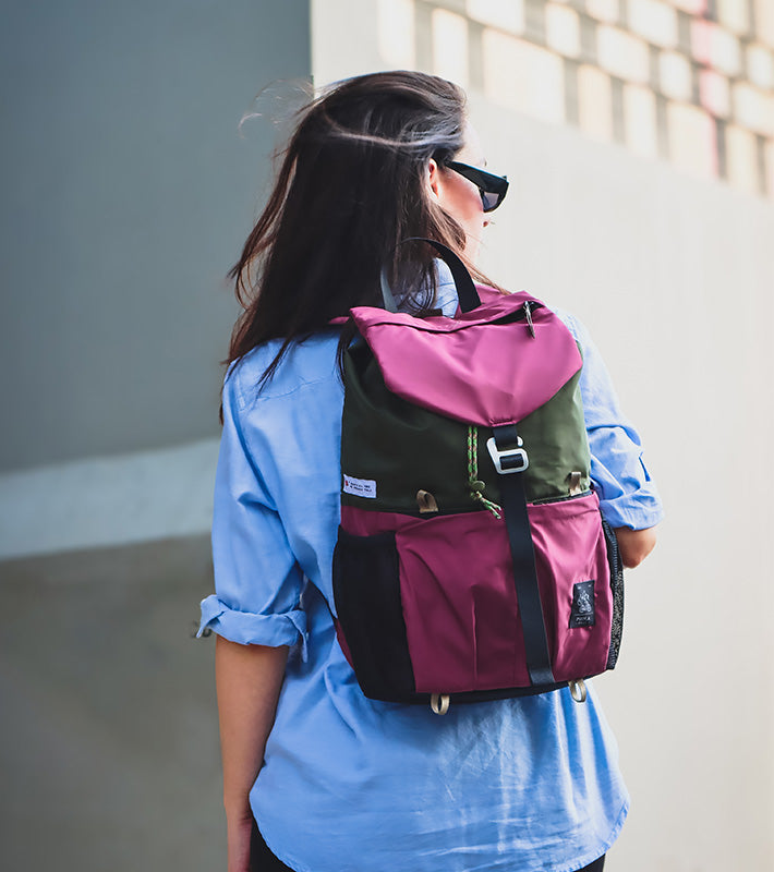 Mochila Trip morada en la espalda de una joven mientras mira el horizonte