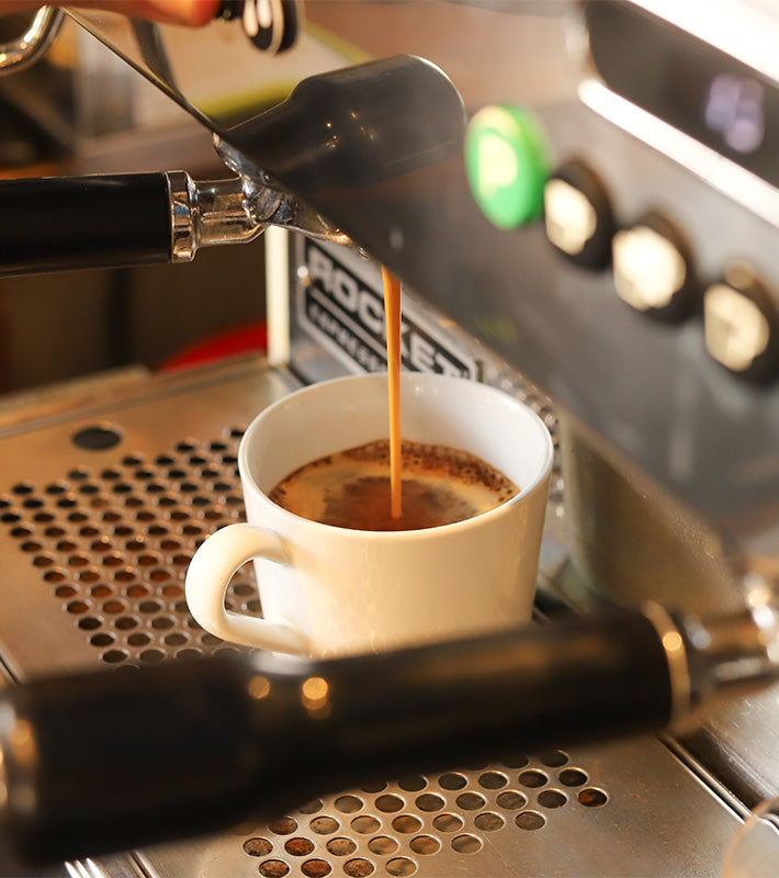 Barista de Piola Bags preparando un espresso en una máquina de café Rocket