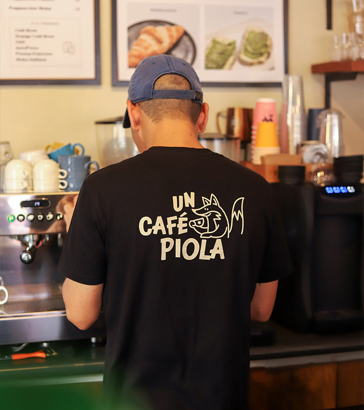 Camiseta del equipo de Piola con el mensaje “Un café Piola” en la parte trasera